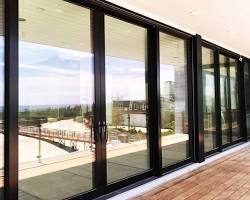 A lift & slide door features large glass panels that glide up slightly before rolling horizontally on a track.